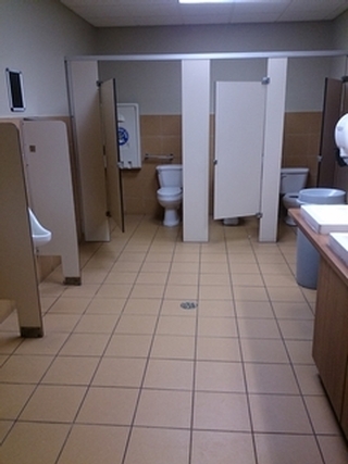 Salle de toilette pour homme avec cabinet de toilette partiellement accessible