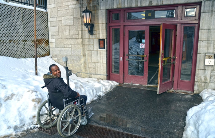 Personne en fauteuil roulant devant l'entrée