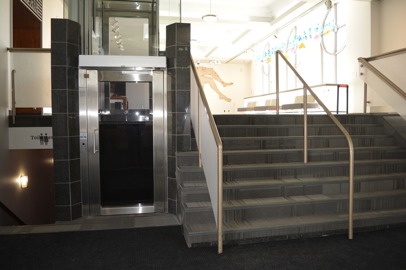Escaliers et lève-personne pour accéder au bar devant l'entrée principale de la salle de spectacle