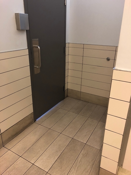Espace de manoeuvre devant la porte situé à l'intérieur de la salle de toilette pour hommes de la gare fluviale de Québec