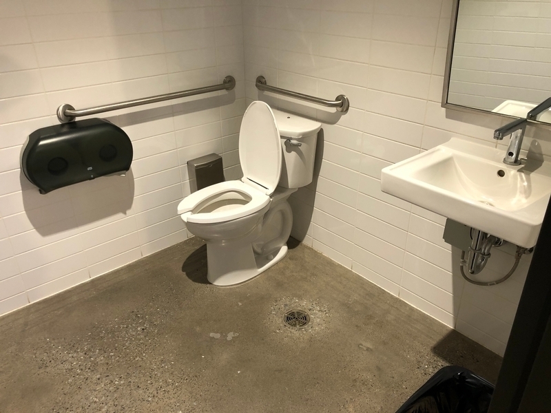 Salle de toilette aménagée pour les personnes handicapées, située près du comptoir d'accueil