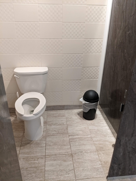 Cabinet accessible dans la salle de toilette des hommes