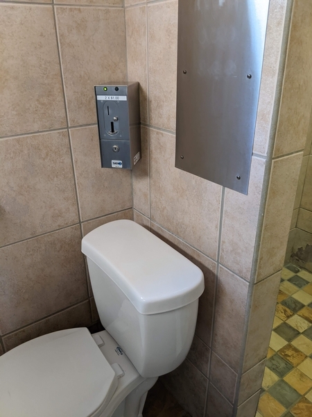 Machine de paiement pour l'eau située par dessus la toilette, difficile d'accès