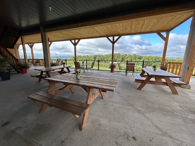 Terrasse avec trois tables à pique-nique accessibles surplombant la vallée de Coaticook 