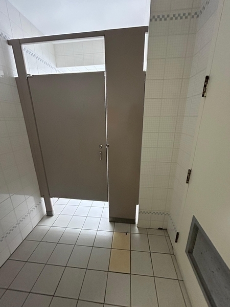 Salle de toilettes hommes - porte de la cabine de toilette accessible