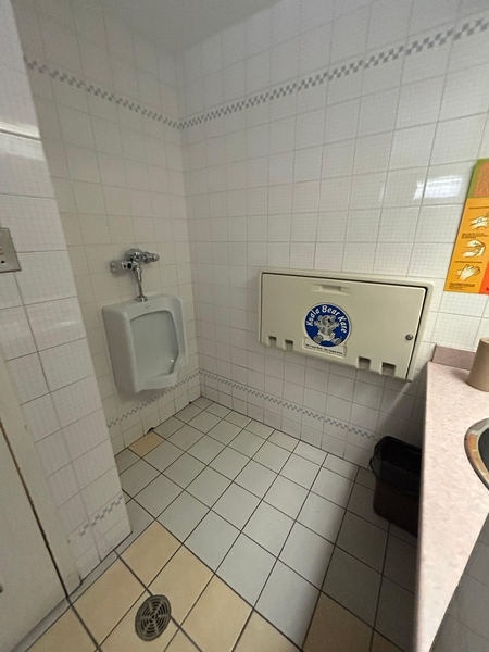 Salle de toilettes hommes - urinoir et table à langer