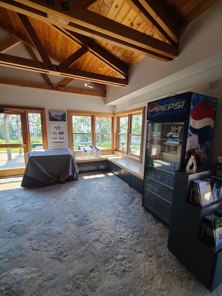 Intérieur du bâtiment et porte menant aux tables accessibles