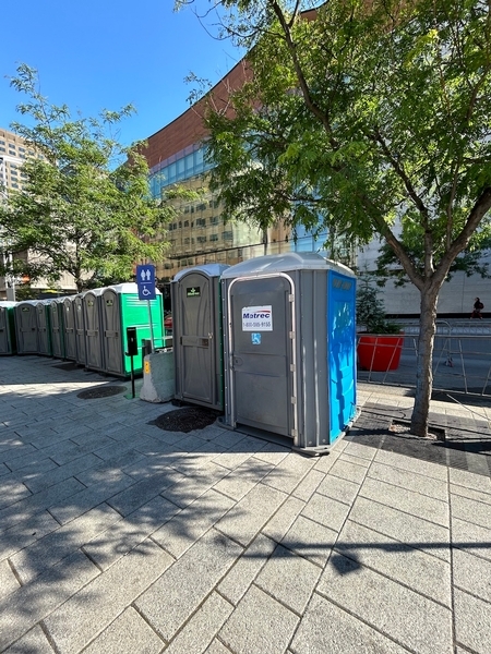 Toilette chimique accessible près de la zone réservée des scènes secondaires